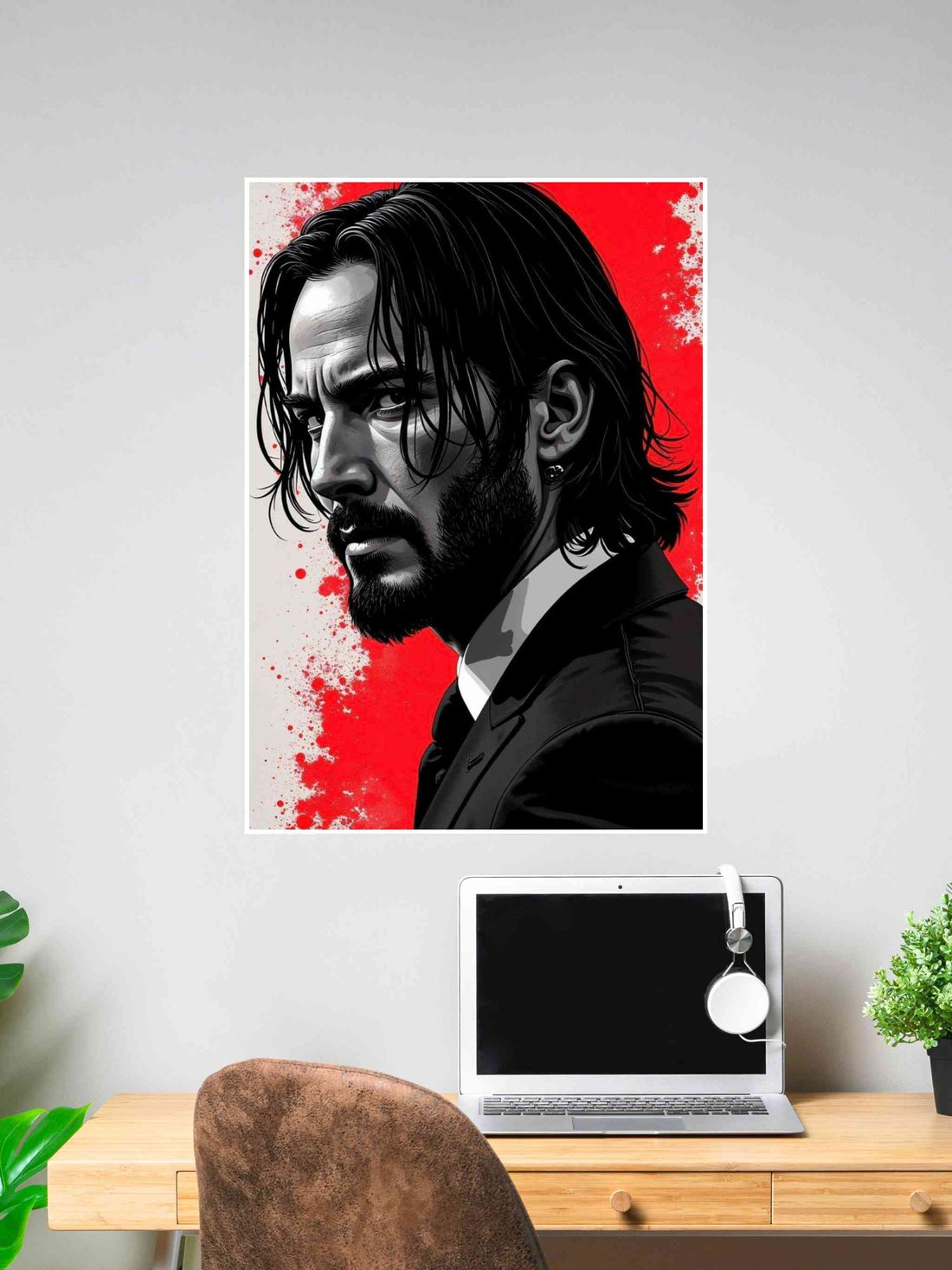 Poster of John Wick in a suit with red splatter background, dark hair, and intense expression, placed above a work desk setup.