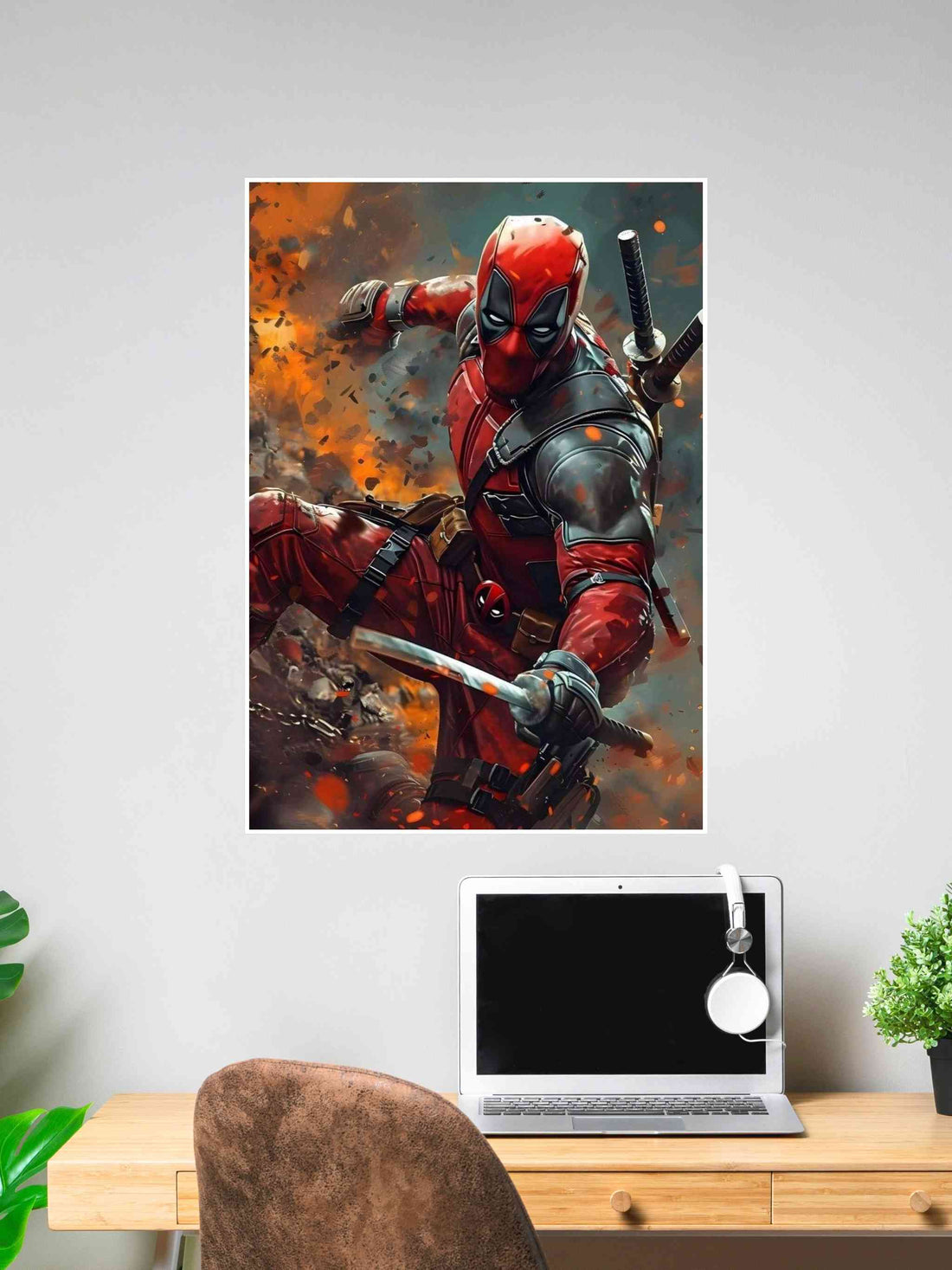 Poster of Deadpool with katanas drawn, leaping through an explosion, mounted above a desk in a stylish workspace.