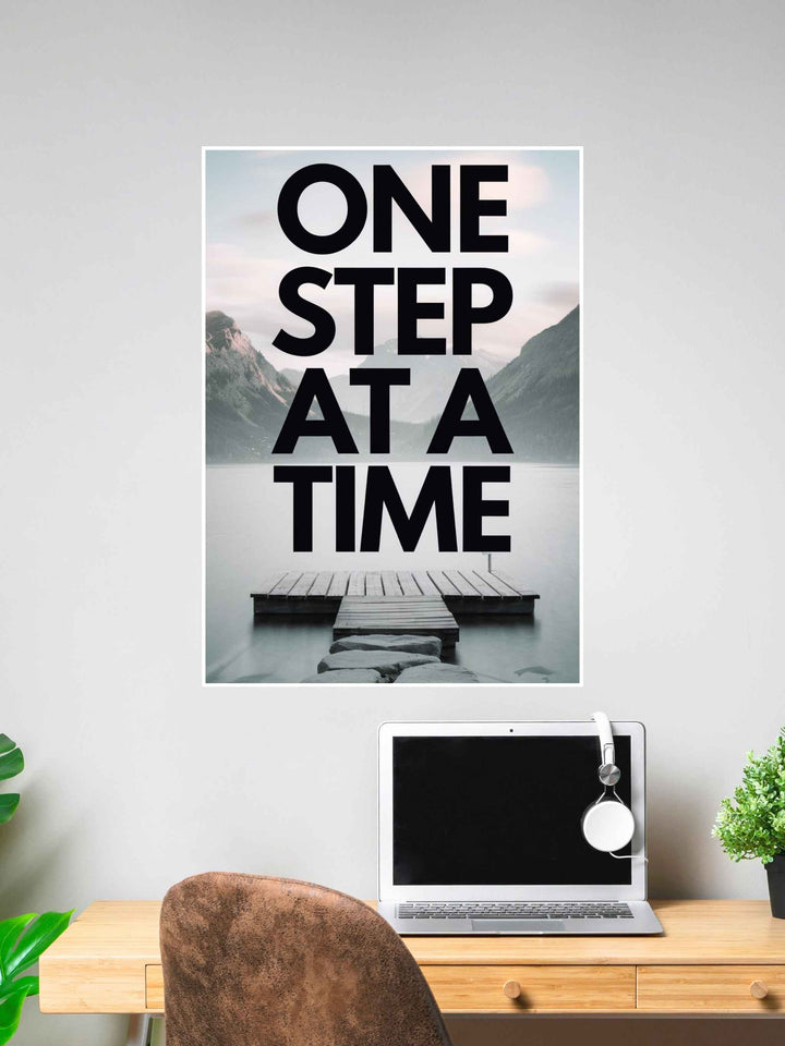Inspirational wall poster with the words “One Step at a Time” over a peaceful lakeside dock background.